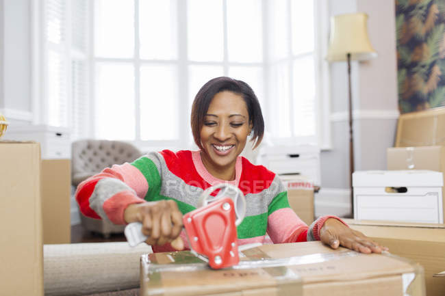 Mujer sonriente grabando cajas móviles, casa móvil - foto de stock