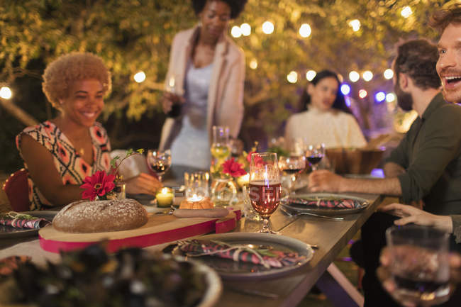Amici godendo cena a lume di candela festa in giardino — Foto stock