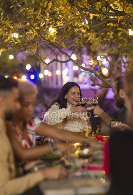 Freunde stoßen Weingläser an, genießen Dinner Gartenparty — Stockfoto