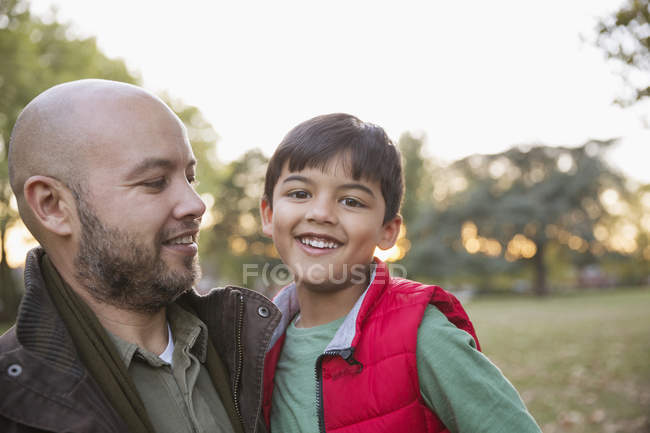 Portrait happy father and son in autumn park — Stock Photo