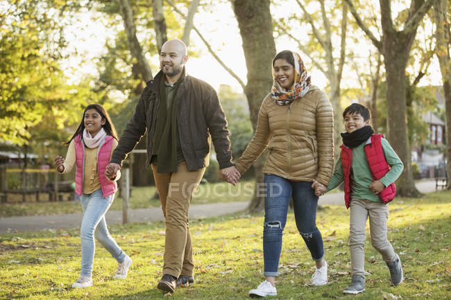 Família muçulmana de mãos dadas, caminhando no parque de outono — Fotografia de Stock