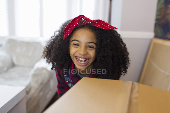 Retrato chica feliz detrás de la caja de cartón, mudarse a una nueva casa - foto de stock