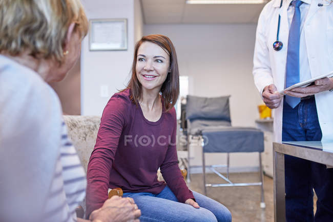 Врач разговаривает с пациентами в кабинете врача — стоковое фото