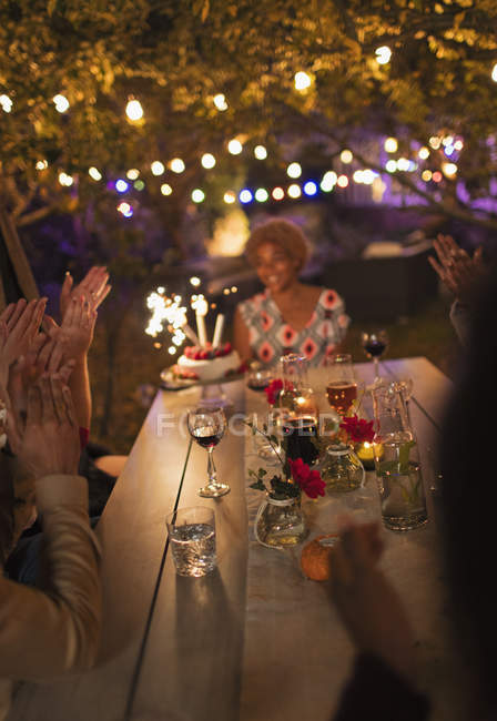 Amici che festeggiano il compleanno al tavolo della festa in giardino — Foto stock