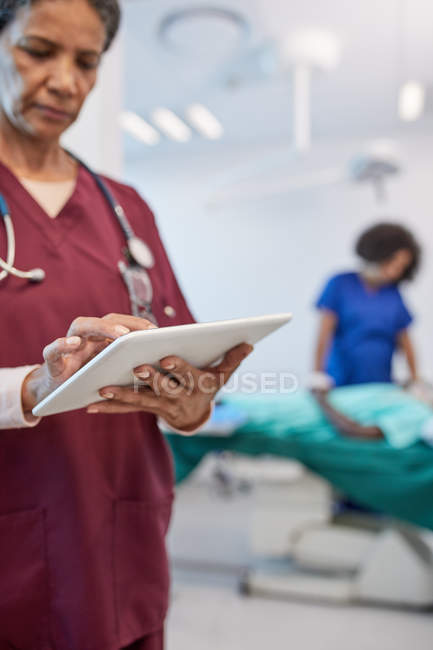 Female doctor using digital tablet in clinic — Stock Photo