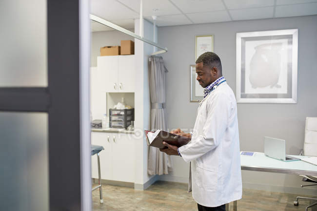 Médico masculino checando cronograma em consultório de médicos de clínica — Fotografia de Stock