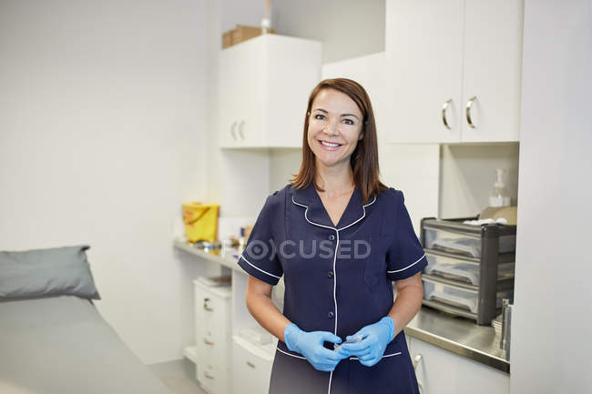 Retrato seguro, feliz enfermera en la sala de examen de la clínica - foto de stock