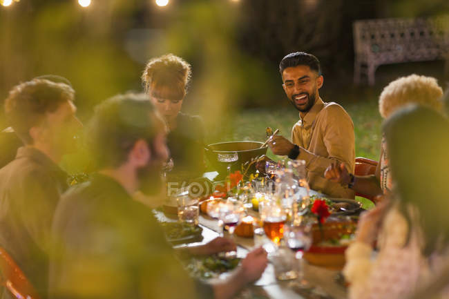 Счастливые друзья наслаждаются ужином в саду — стоковое фото