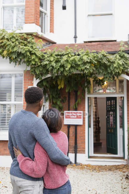 Glückliches Paar umarmt sich vor neuem Haus — Stockfoto