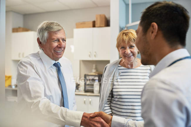 Arzt schüttelt Senioren im Untersuchungsraum der Klinik die Hand — Stockfoto