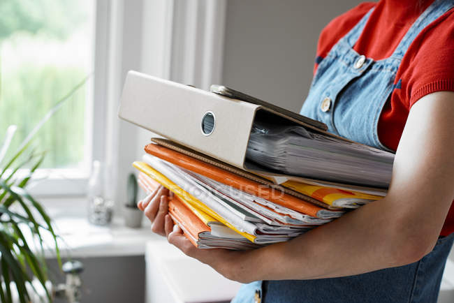 Young female college student carrying stack of books and binder — Stock Photo