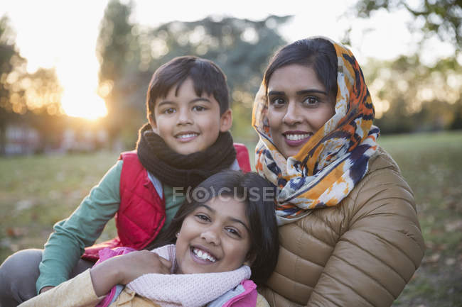 Portrait happy Muslim mother in hijab with children in autumn park — Stock Photo
