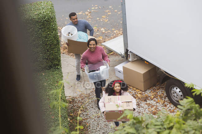 Famiglia che si trasferisce in una nuova casa, portando scatole da furgone in movimento — Foto stock