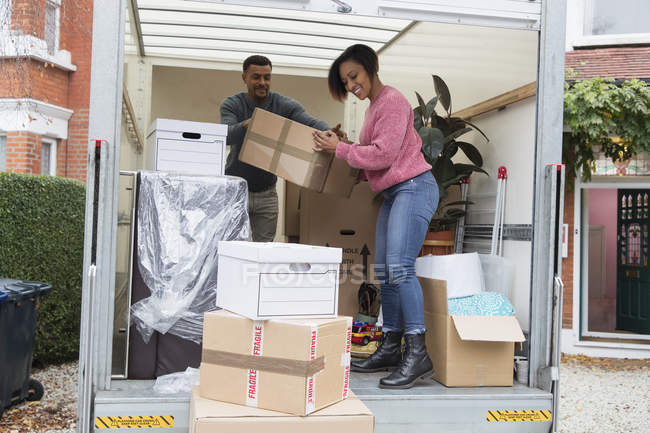 Casal descarregamento movendo van fora nova casa — Fotografia de Stock