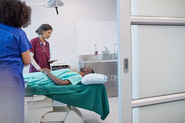 Хирург беседует с пациентом, готовится к операции в клинике — стоковое фото