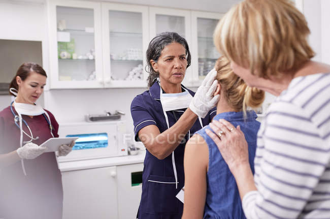 Pediatra feminina examinando paciente menina na sala de exame clínico — Fotografia de Stock