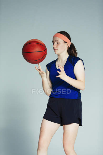 Giocatore di basket adolescente che gira pallacanestro sul dito — Foto stock