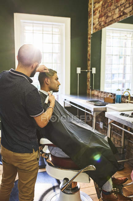 Homem recebendo corte de cabelo na barbearia — Fotografia de Stock