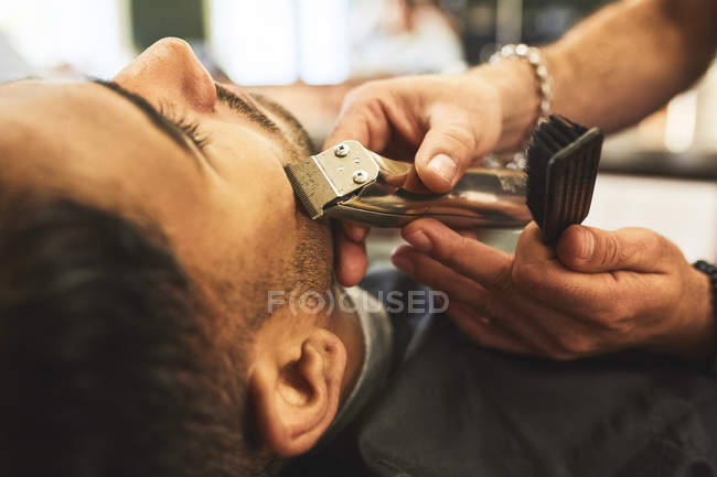 Gros plan homme recevant un rasage dans le salon de coiffure — Photo de stock