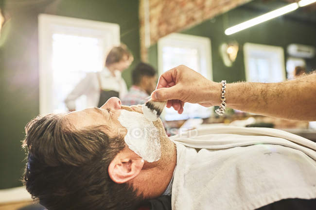 Чоловік голиться в перукарні — стокове фото