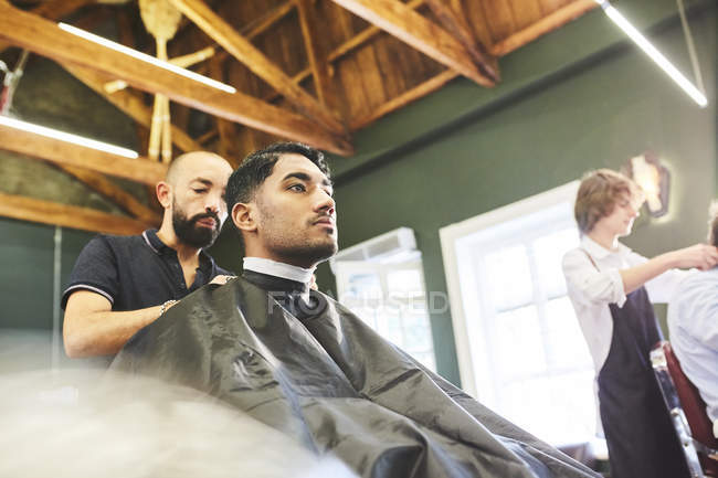 Cliente maschio ottenere un taglio di capelli in barbiere — Foto stock