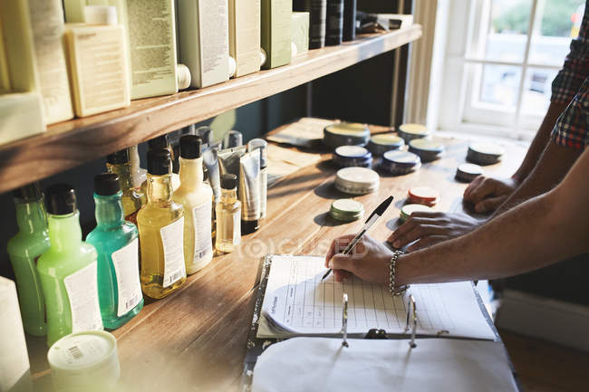 Male barbershop owner checking product inventory — Stock Photo