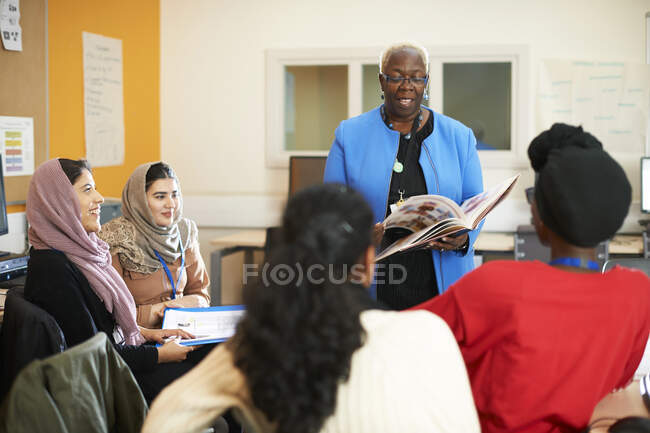 Female teacher and multi-ethnic students in classroom — Stock Photo