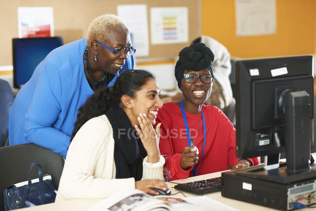 Professora e universitária usando computador em laboratório de informática — Fotografia de Stock