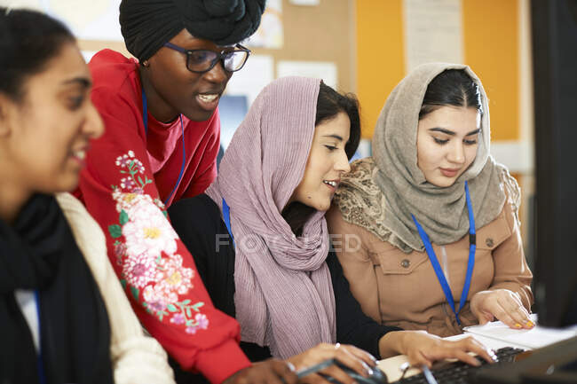 Estudiantes universitarias en hijab y dhuku usando computadora en laboratorio de computación - foto de stock