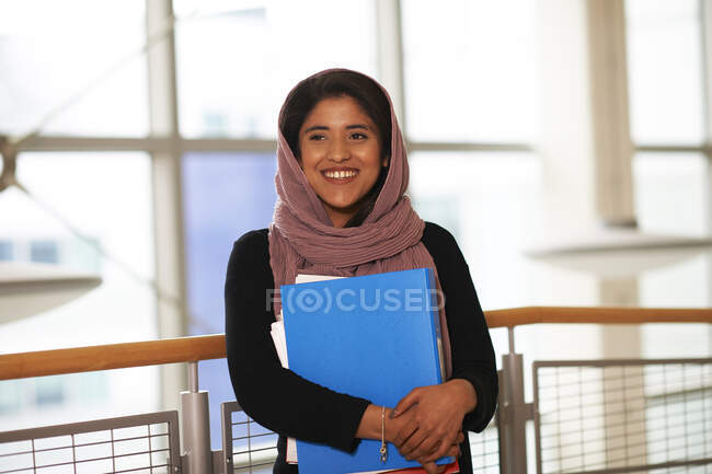 Улыбающаяся, уверенная в себе молодая студентка колледжа в хиджабе — стоковое фото