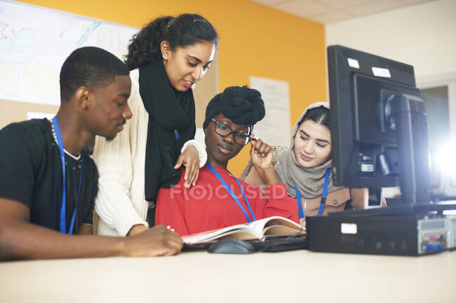 Студенты мультиэтнических колледжей учатся за компьютером в компьютерной лаборатории — стоковое фото