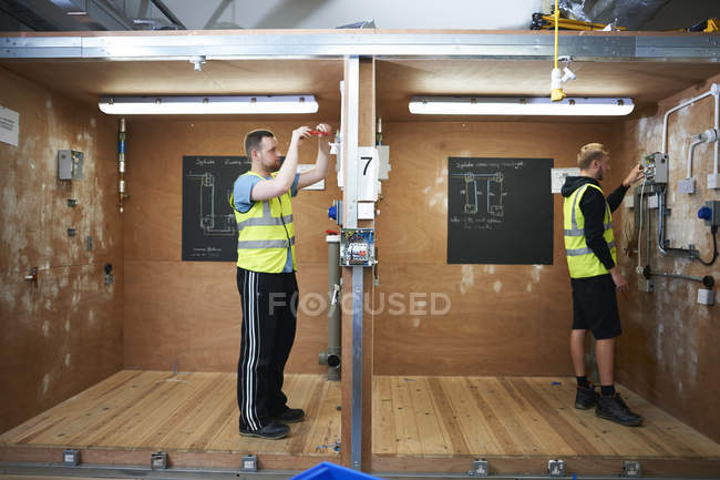 Studenti elettricisti maschi che praticano in laboratorio — Foto stock