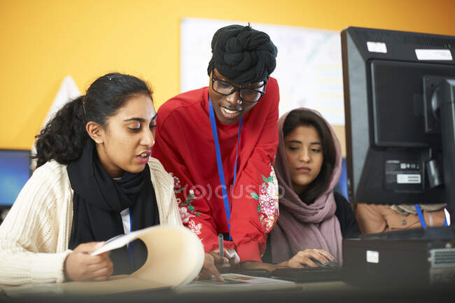 Estudiantes universitarias multi-étnicas usando computadora en laboratorio de computación - foto de stock