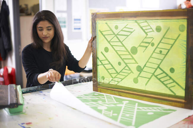 Female artist screen printing in studio — Stock Photo