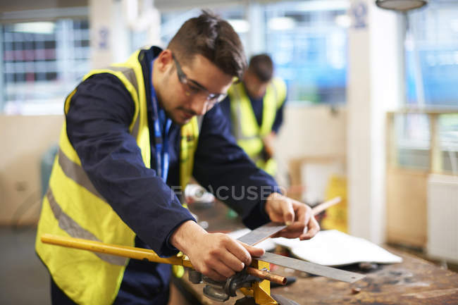 Estudante masculino usando regra carpinteiro em oficina de aula de loja — Fotografia de Stock