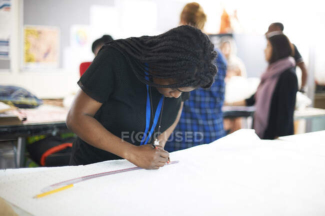 Konzentrierte weibliche Modedesignerin zeichnet Schnittmuster im Studio — Stockfoto