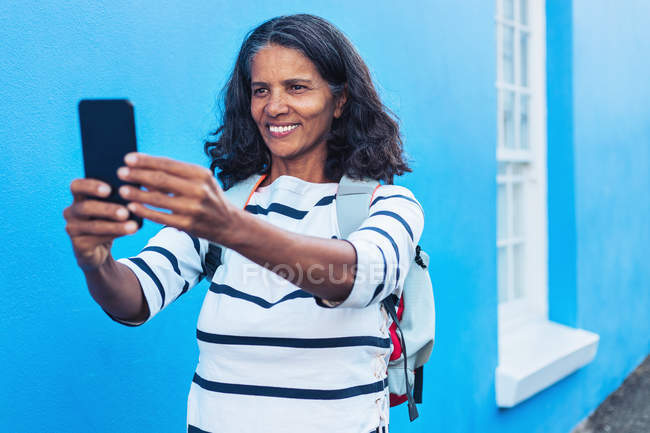 Щаслива жінка-туристка бере селфі зі смартфоном — стокове фото