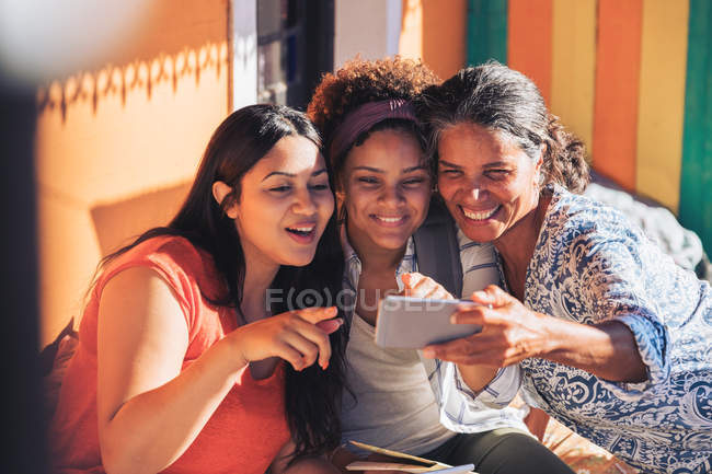 Счастливая мать и дочери делают селфи со смартфоном — стоковое фото