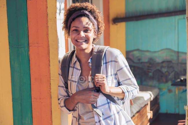Porträt einer lächelnden, selbstbewussten jungen Frau auf der sonnigen Terrasse — Stockfoto