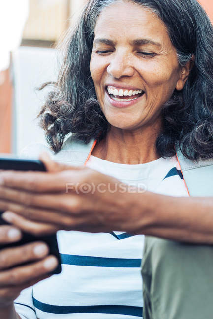 Sonriente, mujer feliz usando teléfono inteligente - foto de stock