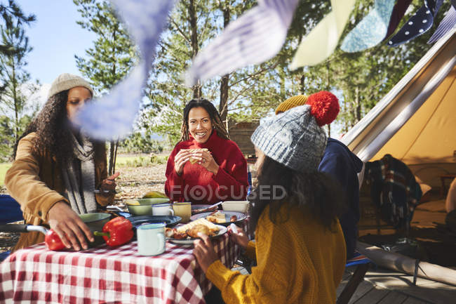 Família comendo na mesa de piquenique do acampamento — Fotografia de Stock
