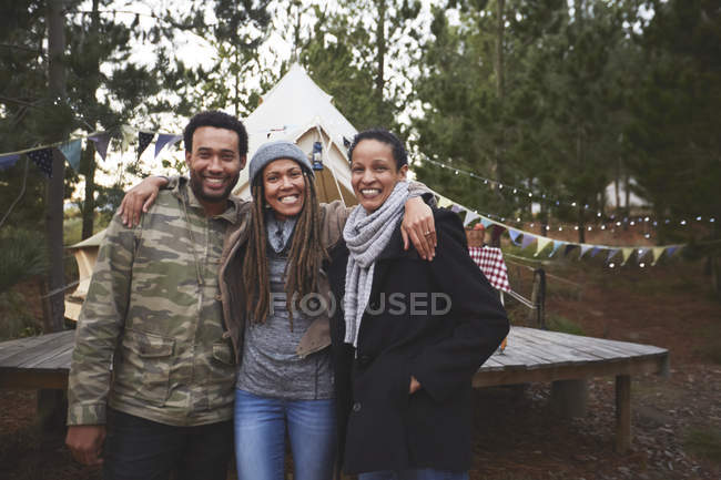 Portrait of happy friends at campsite in woods — Stock Photo