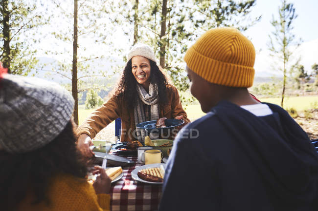 Glückliche Mutter und Kinder essen auf dem Campingplatz — Stockfoto