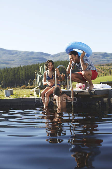 Грайливе сімейне плавання в сонячному, літньому басейні — стокове фото