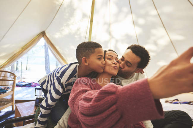 Happy, affectionate family taking selfie in camping yurt — Stock Photo