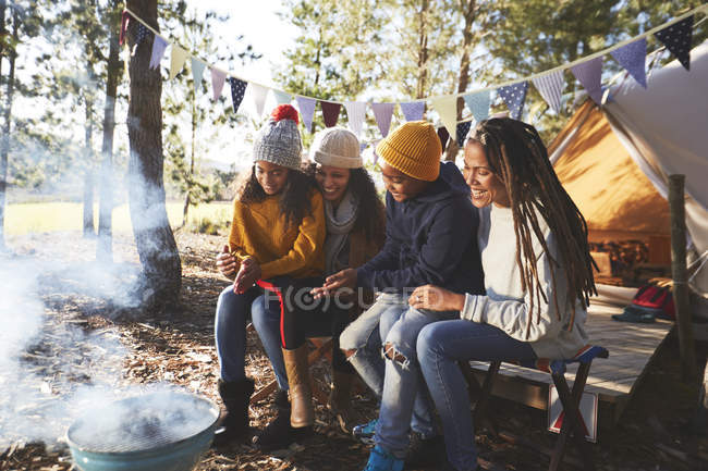 Happy lesbian couple and kids relaxing at campsite in woods — Stock Photo