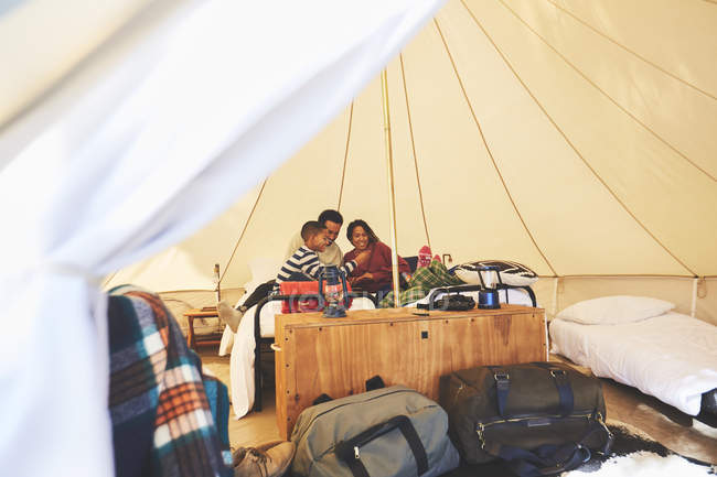 Família relaxante na cama dentro de iurte de acampamento — Fotografia de Stock