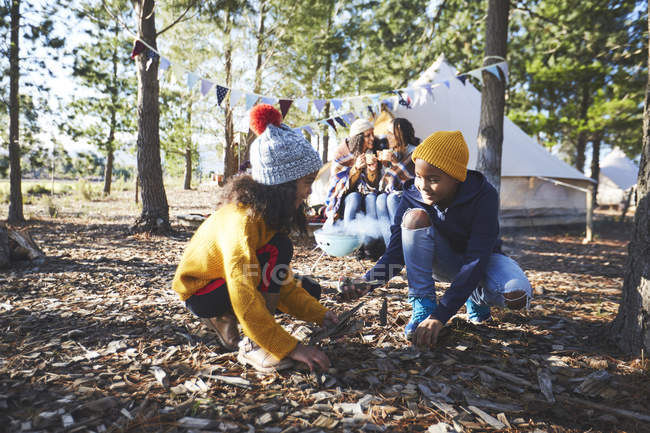 Brother and sister gathering kindling at campsite in woods — Stock Photo