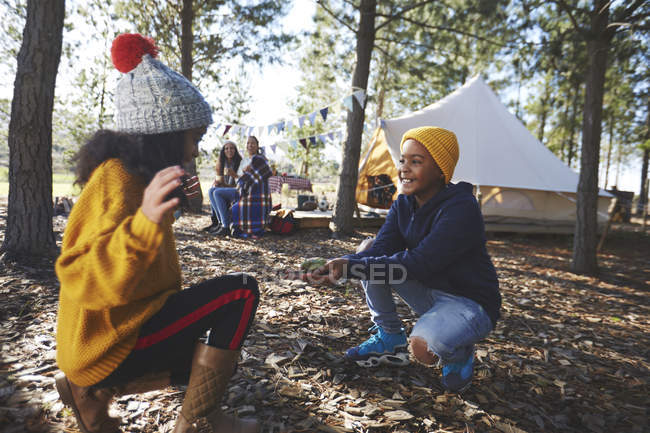 Playful brother showing tree frog to sister at campsite in woods — Stock Photo