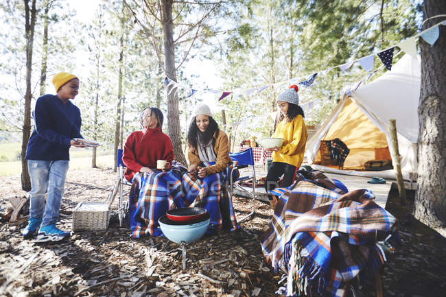 Lesbiennes couple et enfants cuisine au camping grill dans les bois ensoleillés — Photo de stock